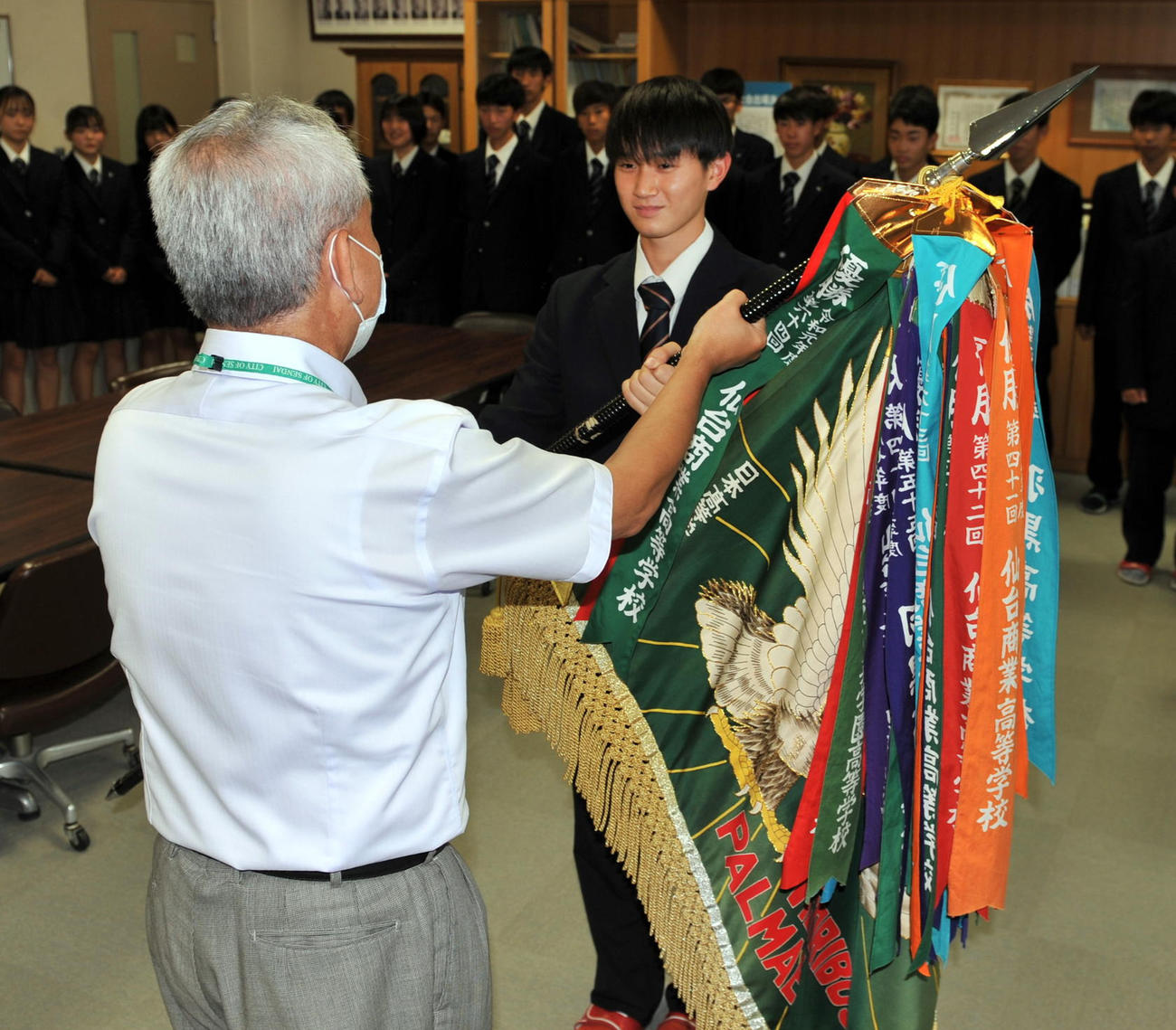 仙台商軟式野球部の高橋前主将（右）が優勝旗を返還（撮影・佐々木雄高）