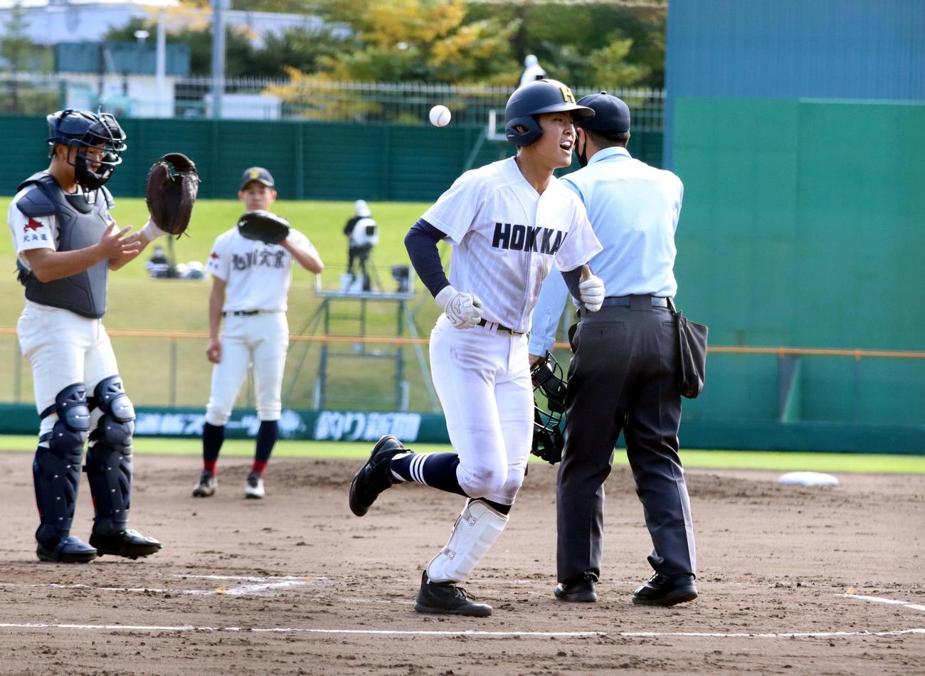 北海対旭川実　8回表北海2死、江口（右）が右越えに先制ソロを放ち声を上げ生還する。左は旭川実バッテリー（撮影・永野高輔）