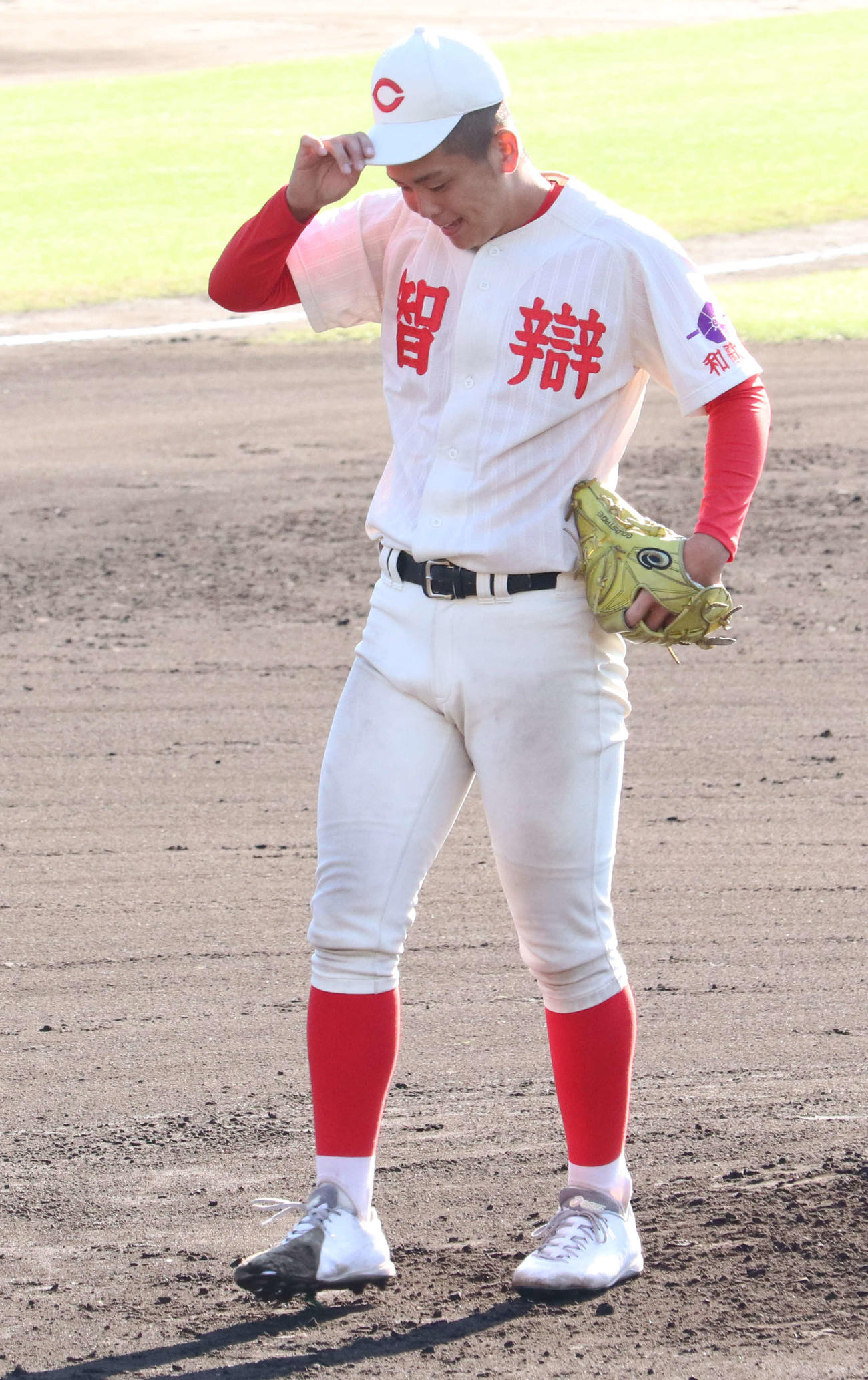 智弁和歌山－市和歌山　初回1死満塁から先制点を献上する押し出し死球を出して苦笑いする智弁和歌山・中西聖輝投手