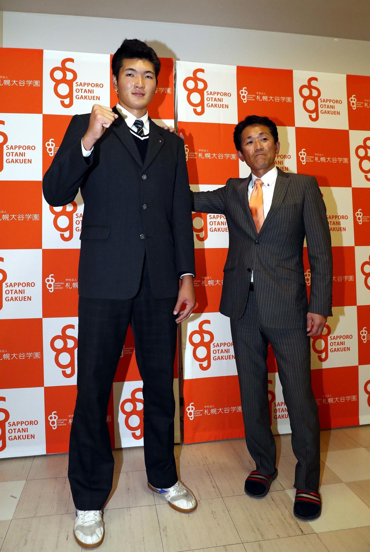 巨人から育成8位で指名され船尾隆広監督から祝福される札幌大谷の阿部（撮影・黒川智章）