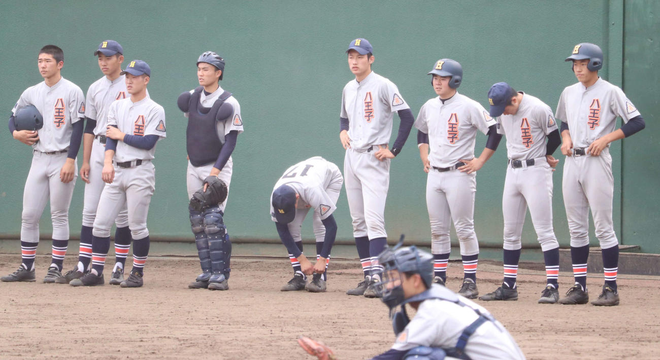 関東第一対八王子学園八王子　イニング間の投球練習を見守る八王子学園八王子・羽田（右から4人目）