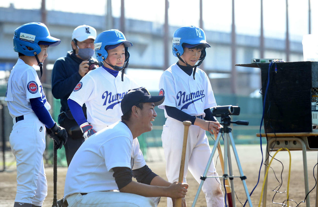 三島南高の選手（手前）と映像を使ってバッティングを確認する沼津リトルの選手たち