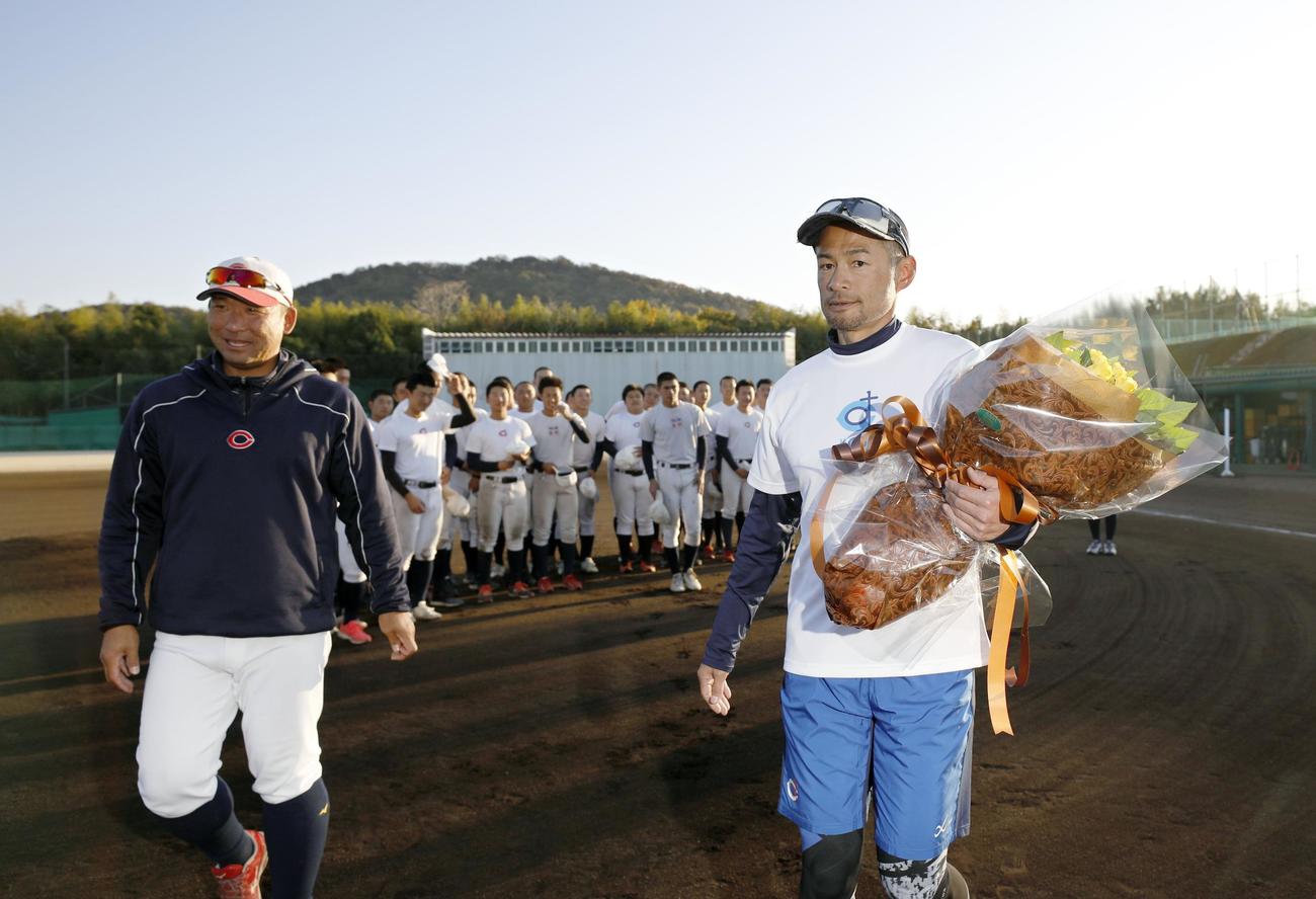 智弁和歌山の指導を終え、花束を手に引き揚げるイチローさん。左は中谷仁監督（代表撮影）