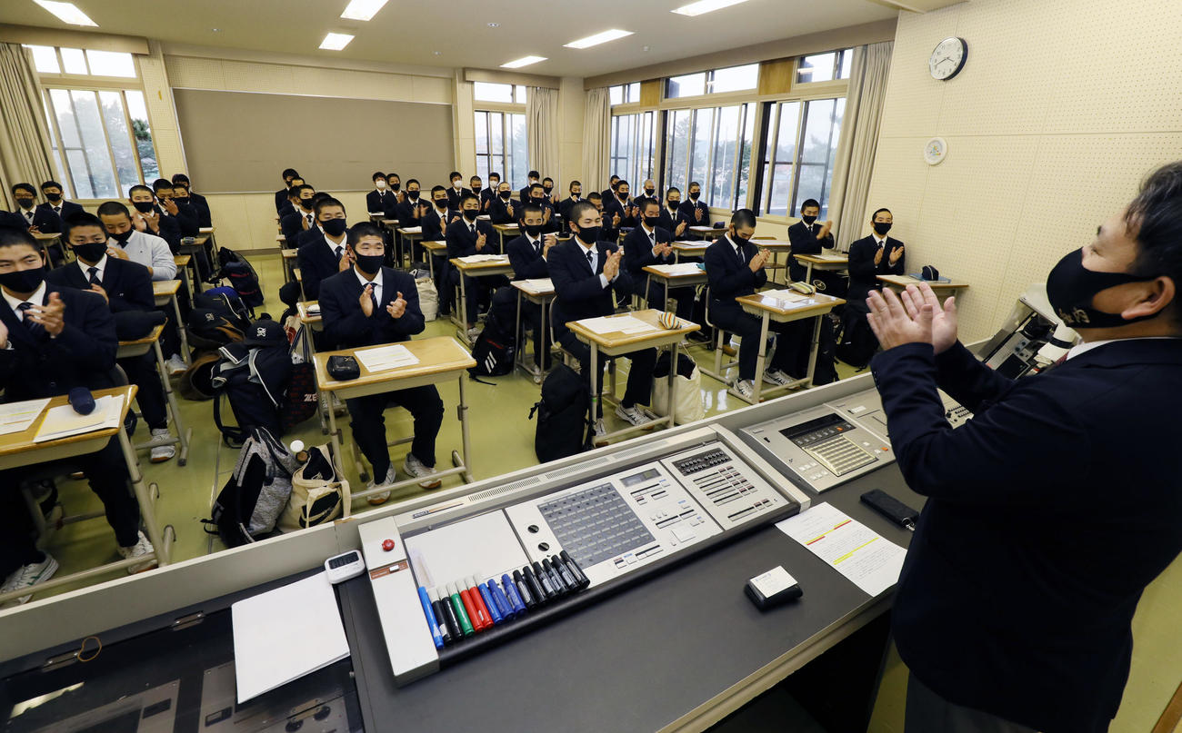センバツ高校野球の21世紀枠候補に選ばれたことを吉川監督から知らされ、拍手する知内の選手たち（代表撮影）