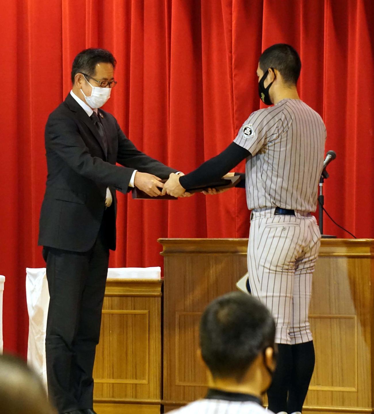 伝達式で記念盾を受け取る知内の川村主将（右）（知内野球部提供）