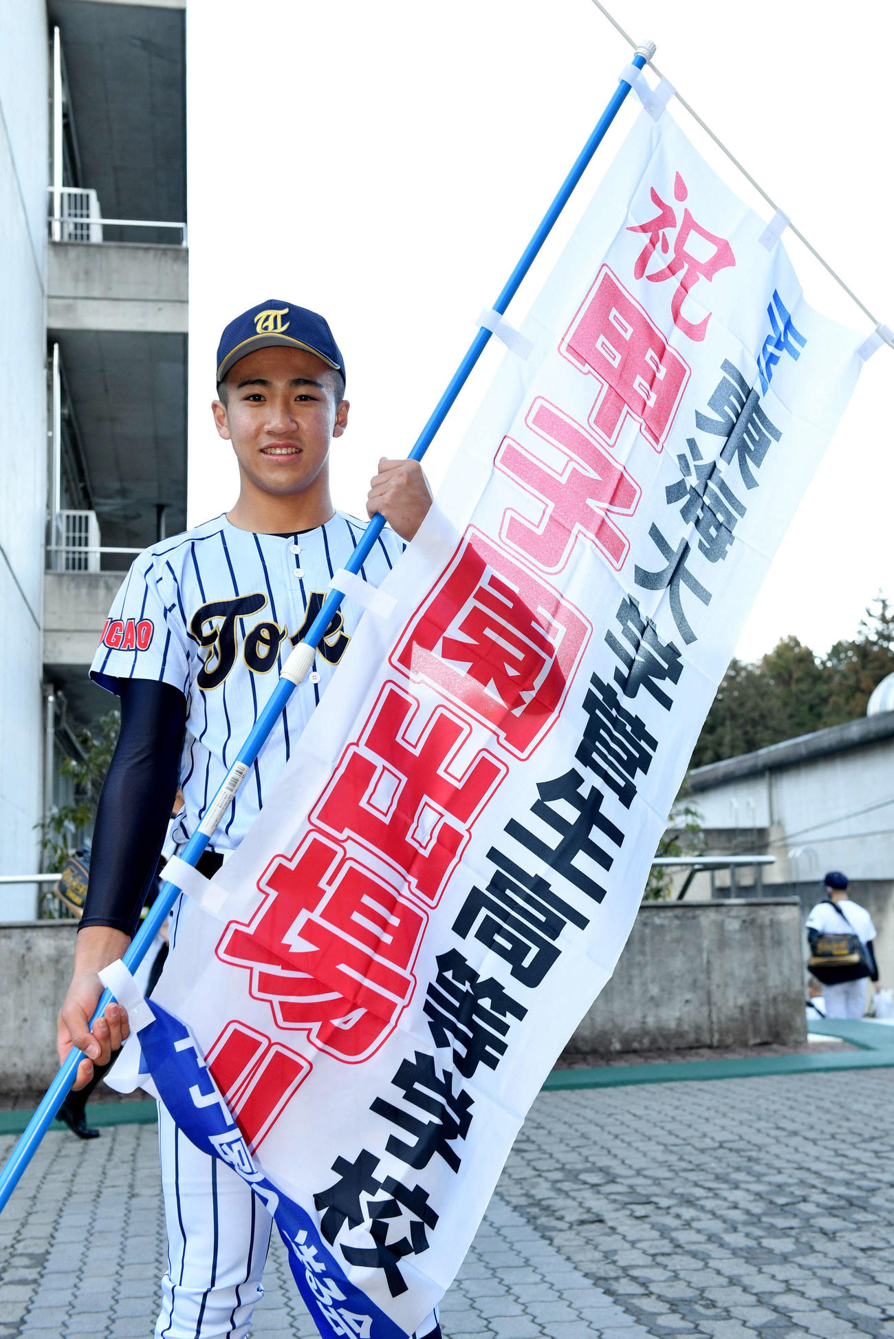 センバツ出場を祝うのぼりを手にする東海大菅生・小池（撮影・滝沢徹郎）