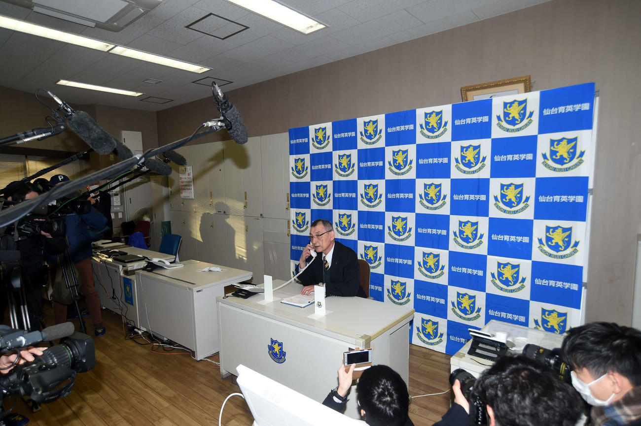 センバツ選出を伝える電話を受ける仙台育英・遠藤教頭（中央）（撮影・相沢孔志）