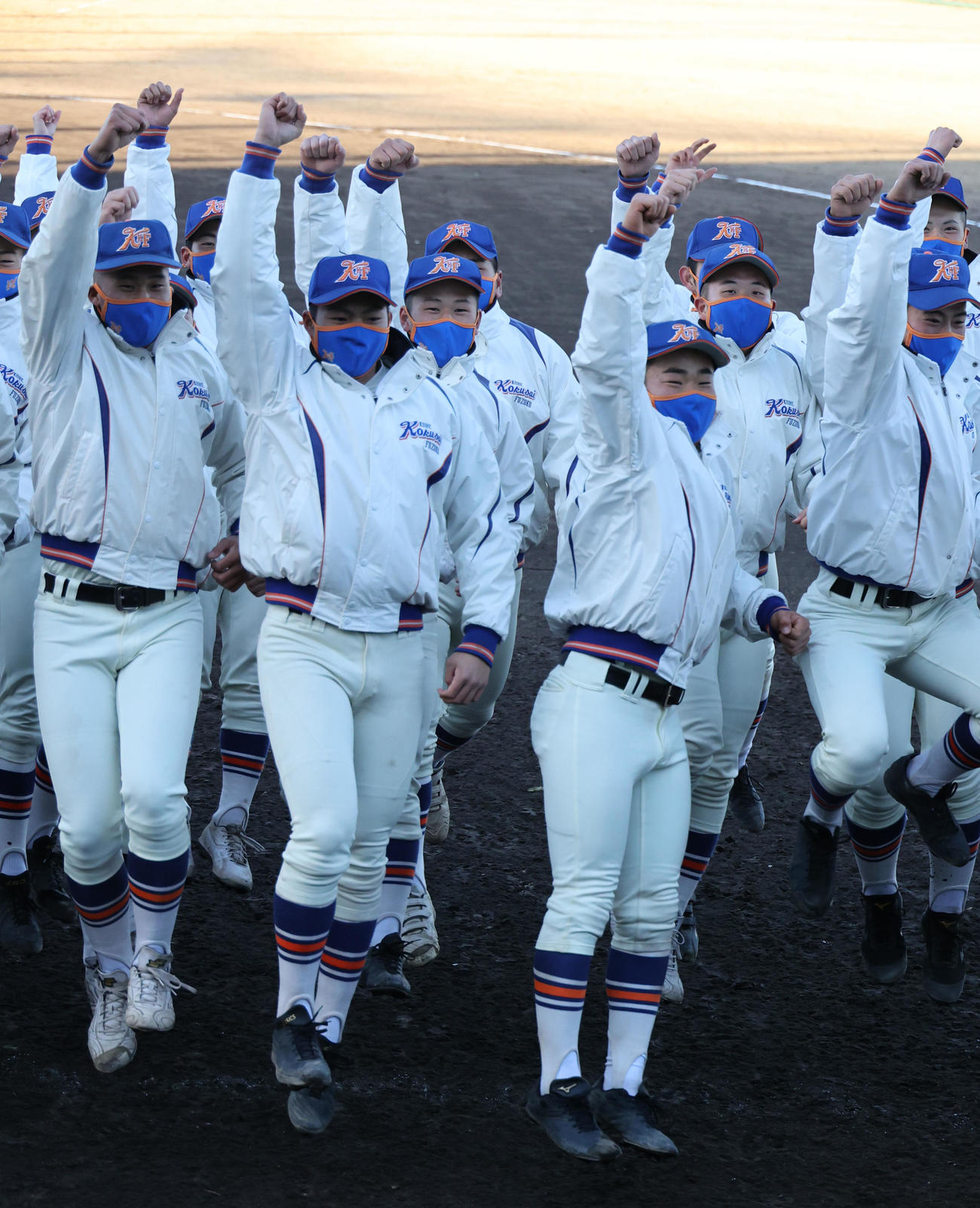ジャンプし喜ぶエースの阪上（前列中央）と西川主将（同右）ら神戸国際大付ナイン（撮影・渦原淳）