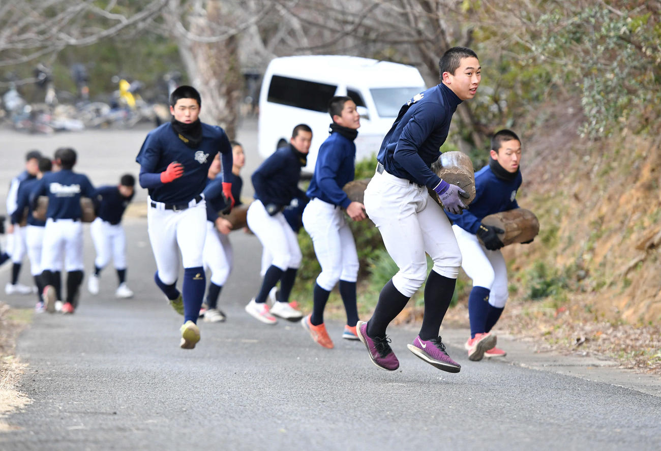 丸太を持って坂道を駆け上がる大崎ナイン（撮影・岩下翔太）