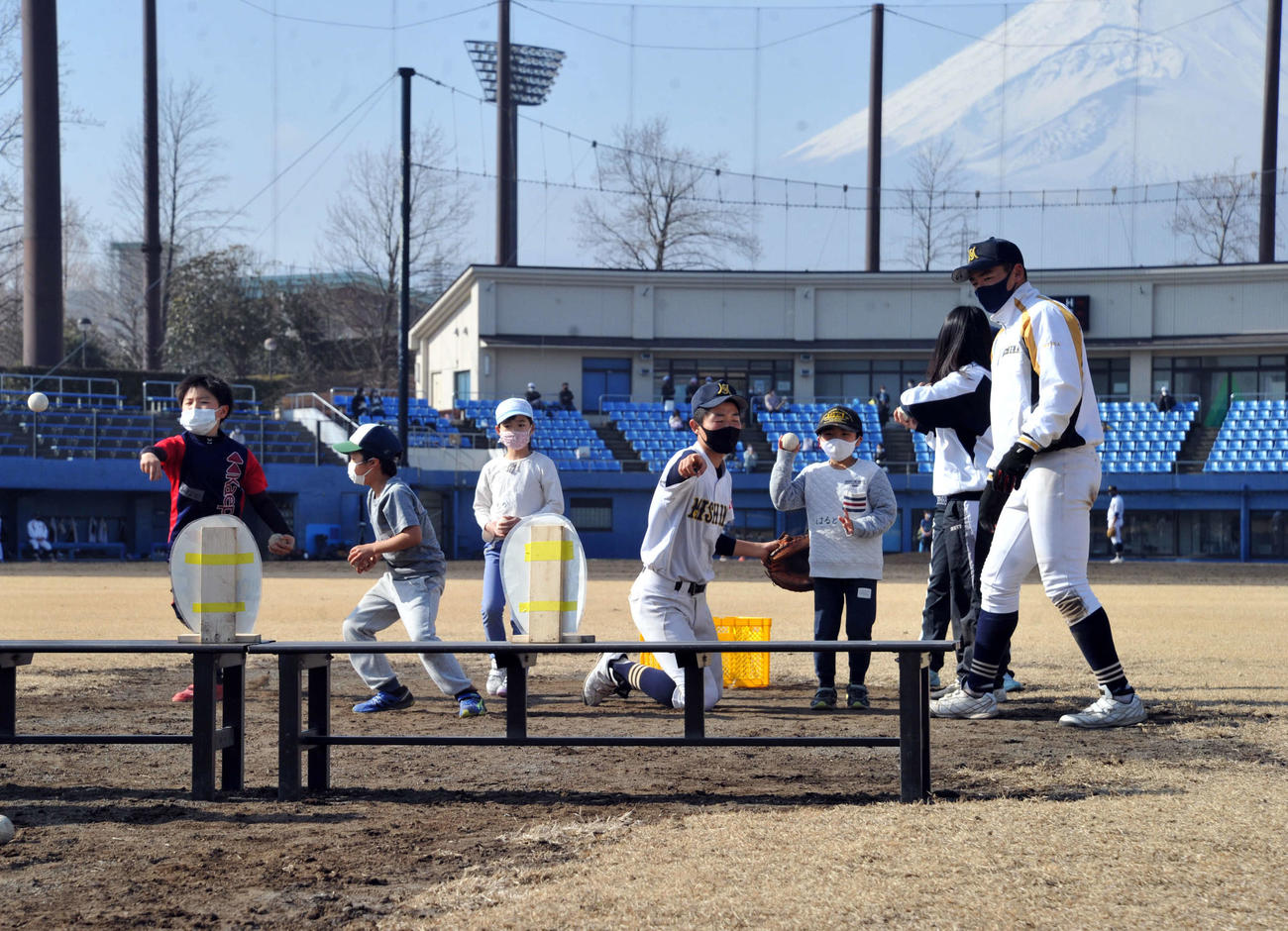 的当てを楽しむ参加者と、指導する三島南高野球部の選手たち