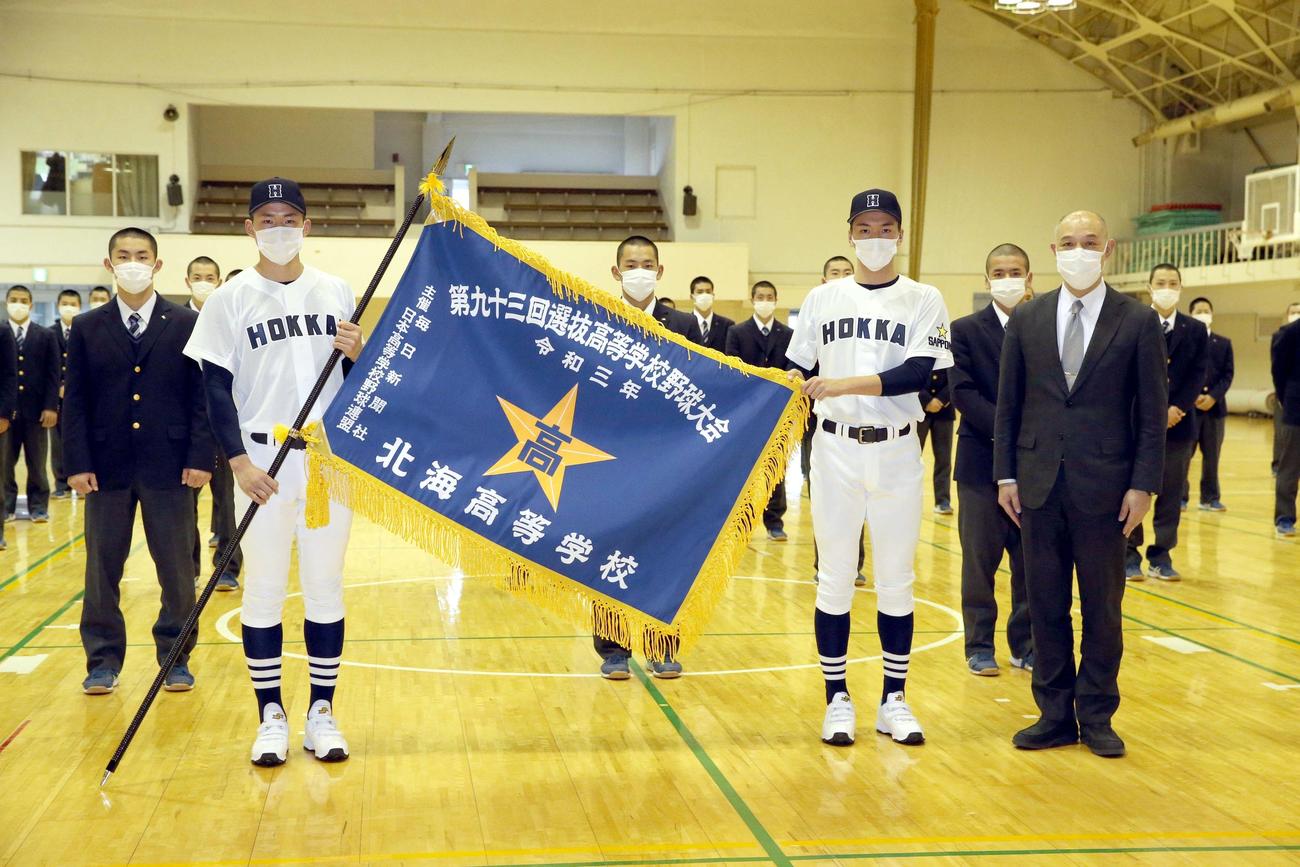 選抜旗授与式を終え記念撮影をする北海の選手たちと秋山校長（右手前）（撮影・佐藤翔太）