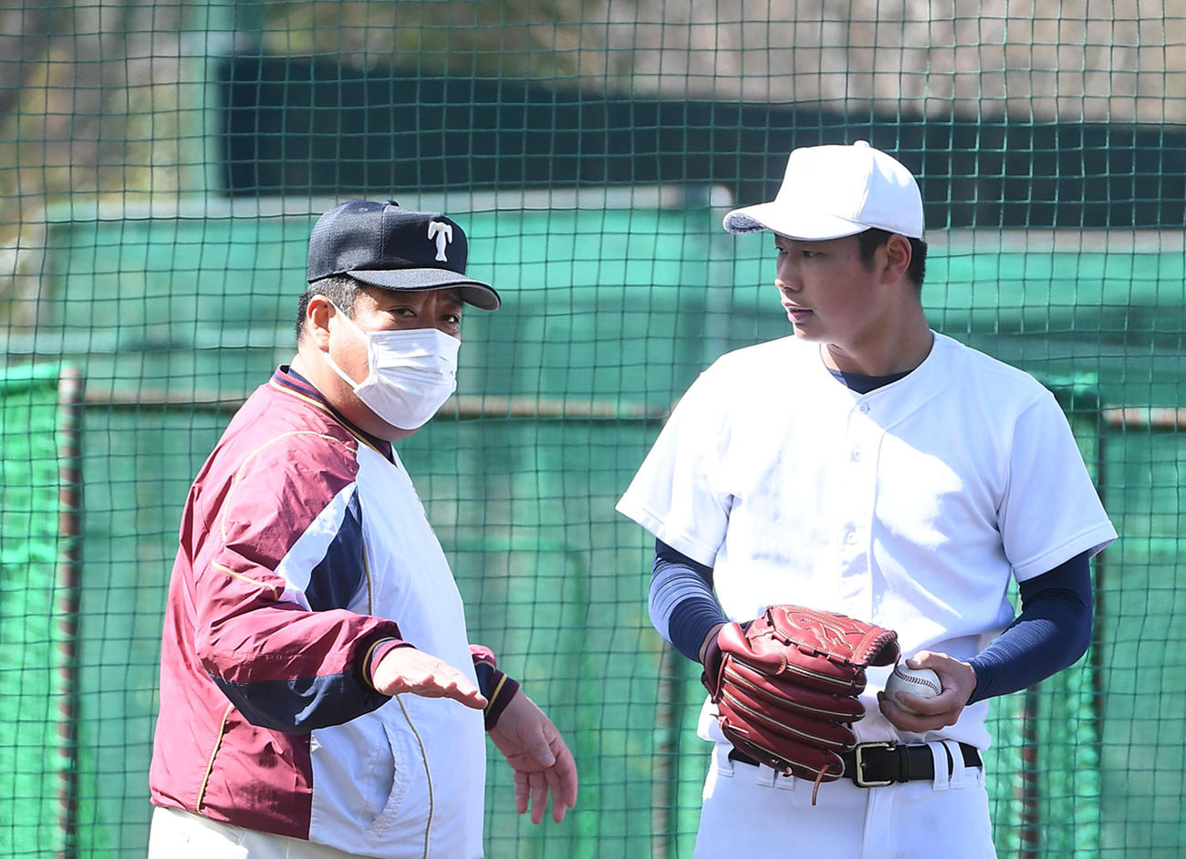 ブルペンで投球練習を行う松浦（右）にアドバイスをする大阪桐蔭・西谷監督（撮影・前岡正明）