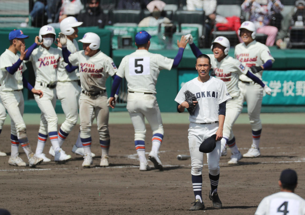 19日のセンバツ1回戦、10回裏にサヨナラ打を浴び、歓喜する神戸国際大付ナインを背に悔しそうな表情の北海・木村