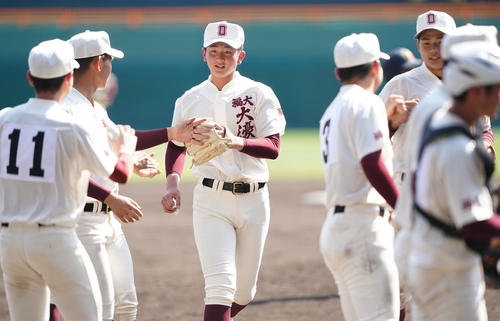 具志川商に勝利し、最後を締めくくった福岡大大濠・馬場（中央）はナインにタッチで迎えられる（撮影・菅敏）