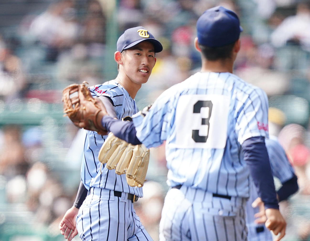 福岡大大濠に完封で勝利し、ナインとタッチをする東海大相模・石田（左）（撮影・菅敏）
