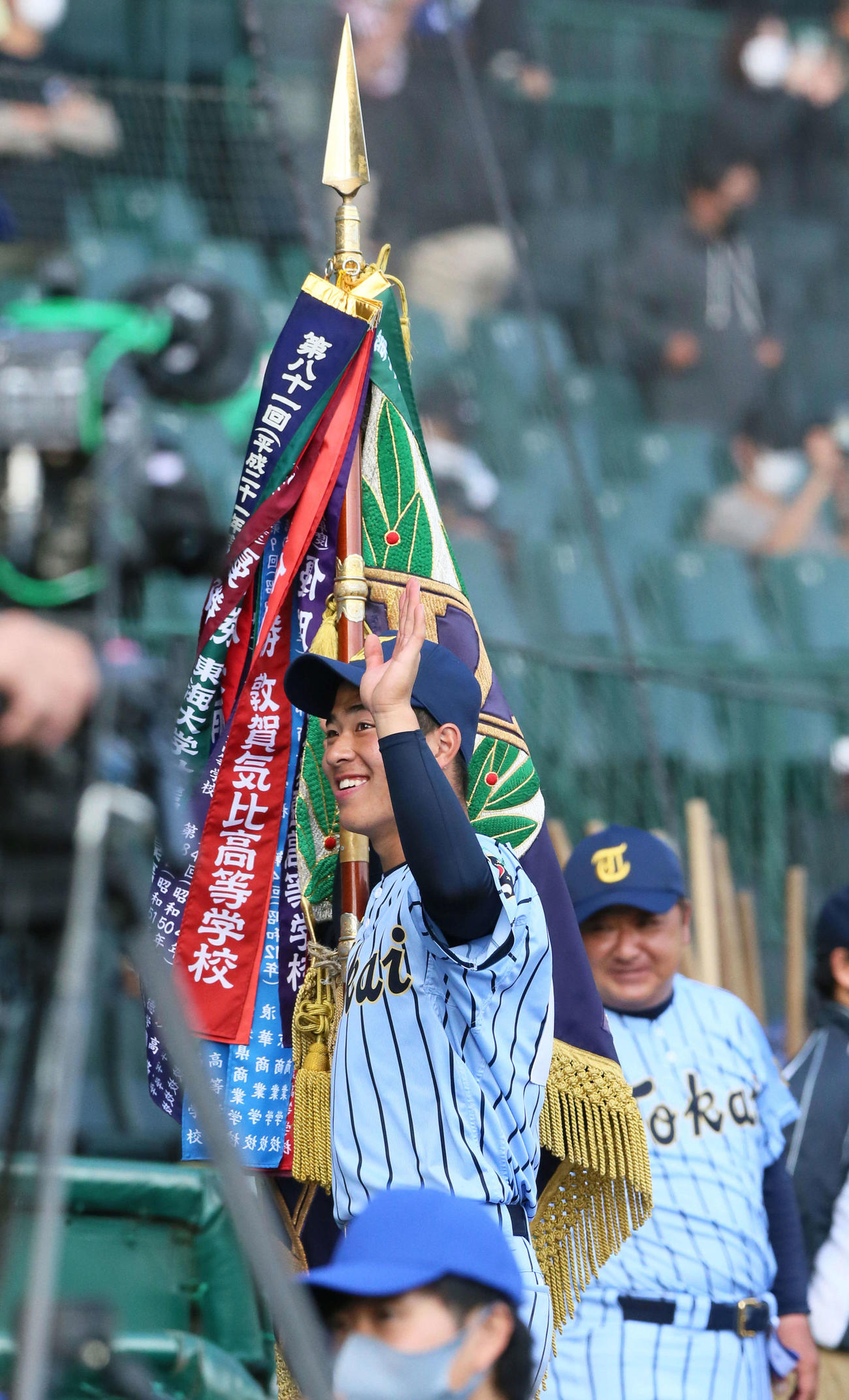 優勝旗を持って笑顔で手を振る東海大相模の門馬、右後方は見つめる門馬監督（撮影・上山淳一）