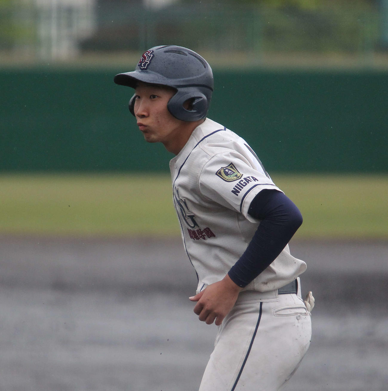 「どうだ」とばかり一塁上で自軍ベンチを見る関根学園・大竹