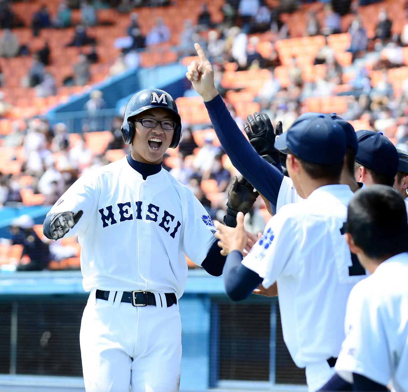 5回裏、先制の本塁を踏んだ藤枝明誠・山田はハイタッチで出迎えられる