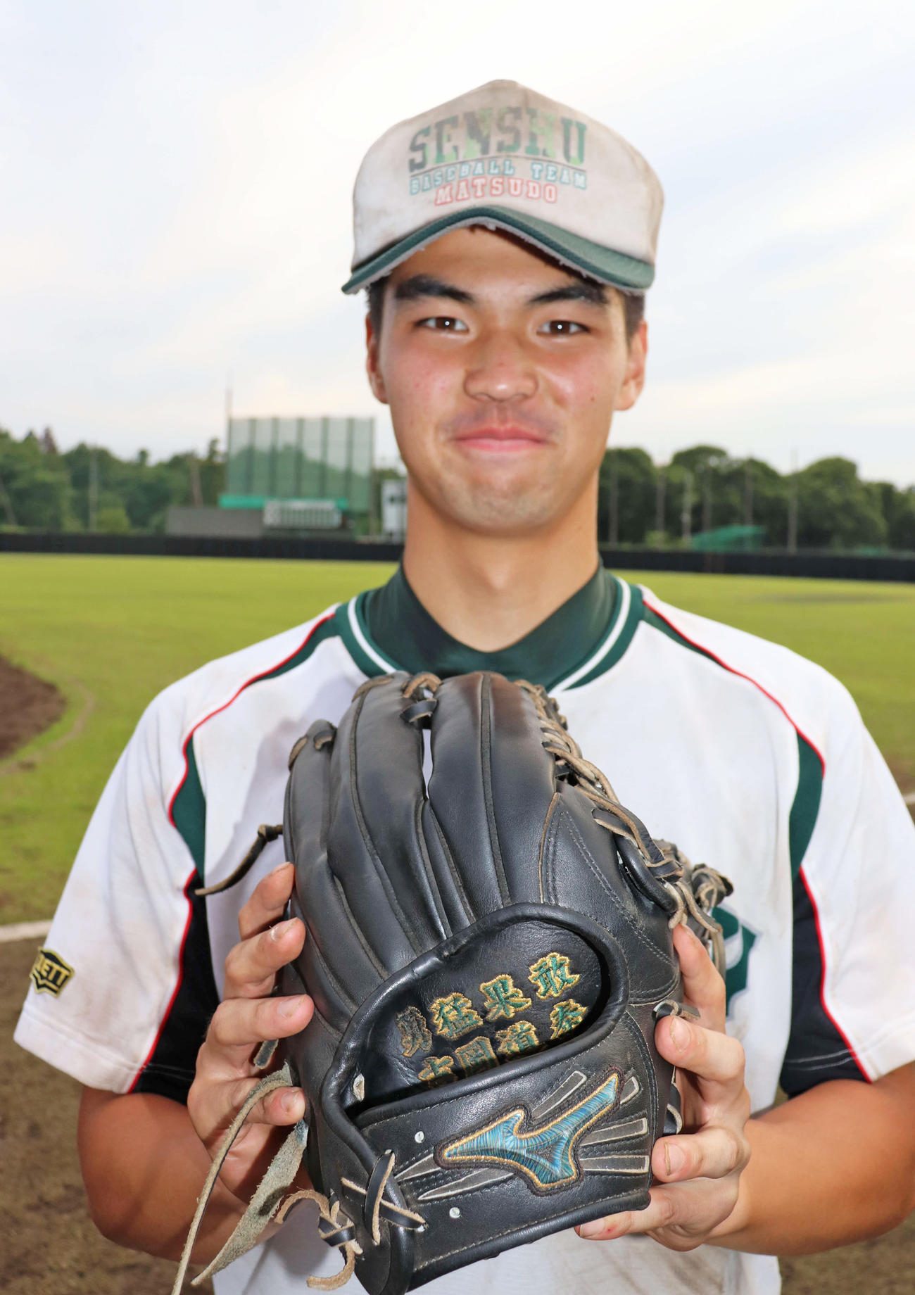 夏は必ず甲子園で勝利すると誓い、「勇猛果敢」と刺しゅうしたグラブを手に笑顔を見せる専大松戸・吉岡（撮影・保坂淑子）