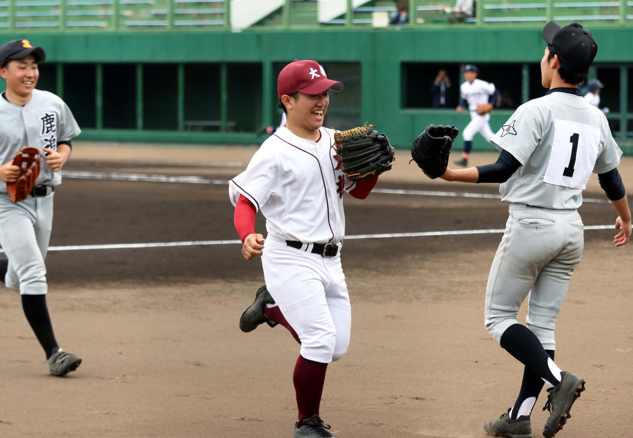 2回に好守を見せ笑顔でベンチに引き揚げる大樹・長谷川三塁手（中央）を、鹿追・佐藤投手が出迎える（撮影・永野高輔）