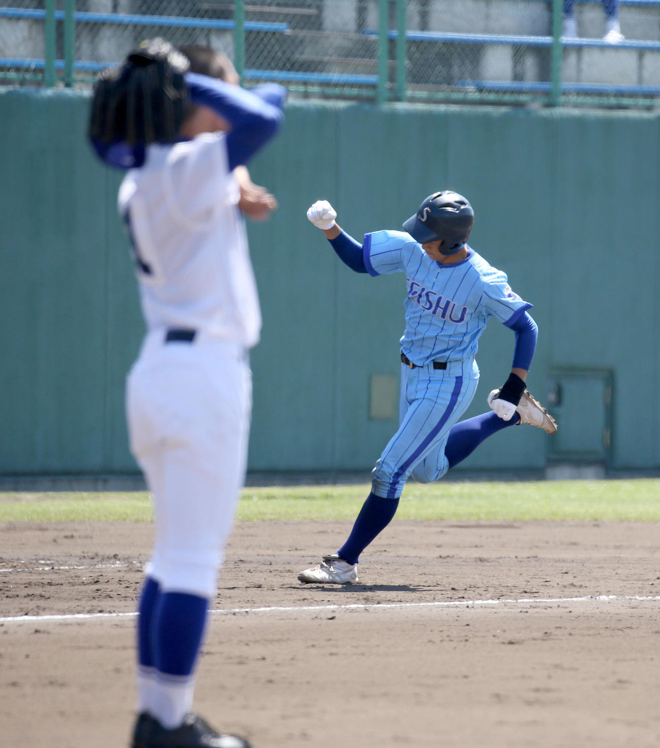 札幌龍谷対札幌静修　5回裏札幌静修1死三塁、左越え2点本塁打を放ちガッツポーズをする小飼（右奥）。左手前は打たれた札幌龍谷学園・木内（撮影・佐藤翔太）