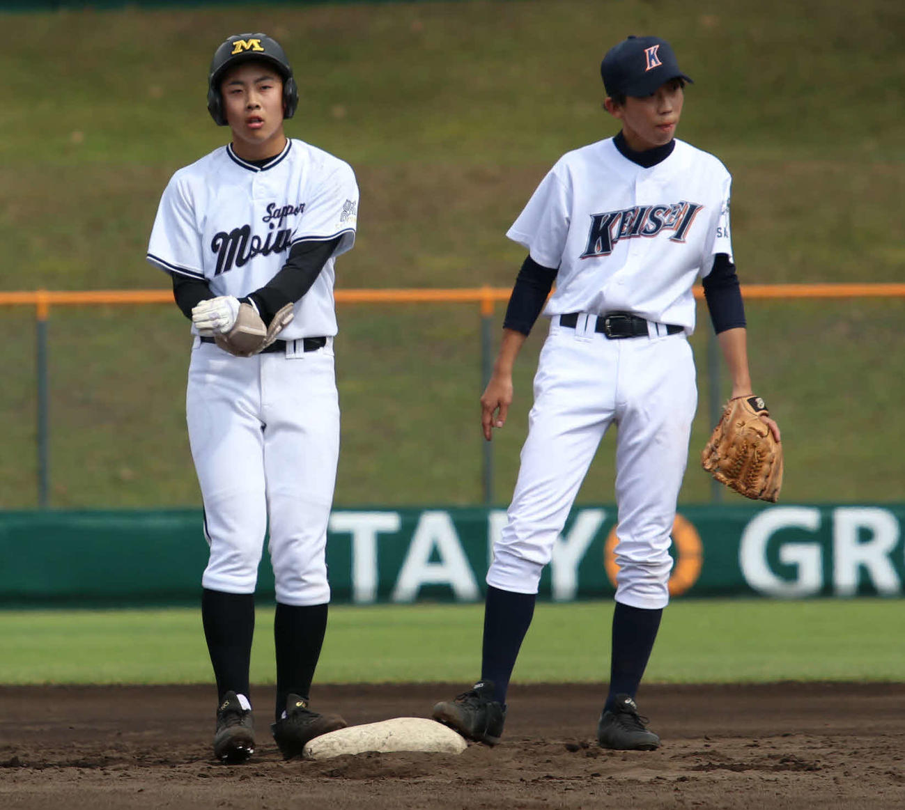 札幌藻岩対札幌啓成　3回裏札幌藻岩1死満塁、適時二塁打を放ち塁上でエルボーガードを外す高橋（左）（撮影・山崎純一）