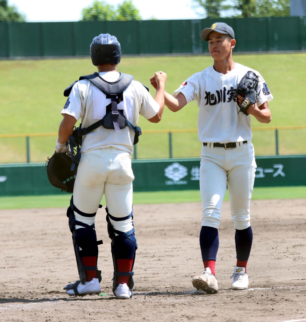 旭川実対旭川明成　先発し9回12奪三振完封した旭川実・田中楓（右）は北口とグータッチする（撮影・永野高輔）