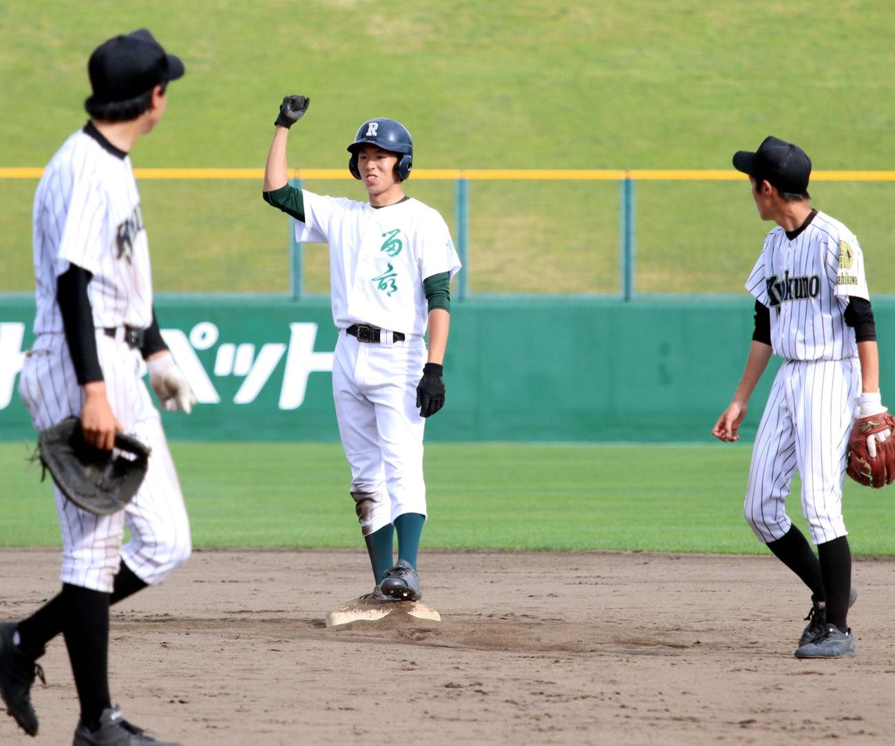 留萌対旭川農　延長11回表留萌無死一、二塁、古岡（中央）が勝ち越しの2点適時二塁打を放ち、塁上で右手を掲げる（撮影・永野高輔）