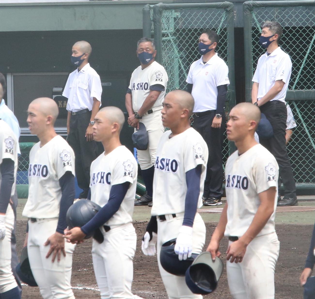 明桜館対鹿児島商　試合後、校歌を聞く鹿児島商・横田監督（後方左から2人目）（撮影・菊川光一）
