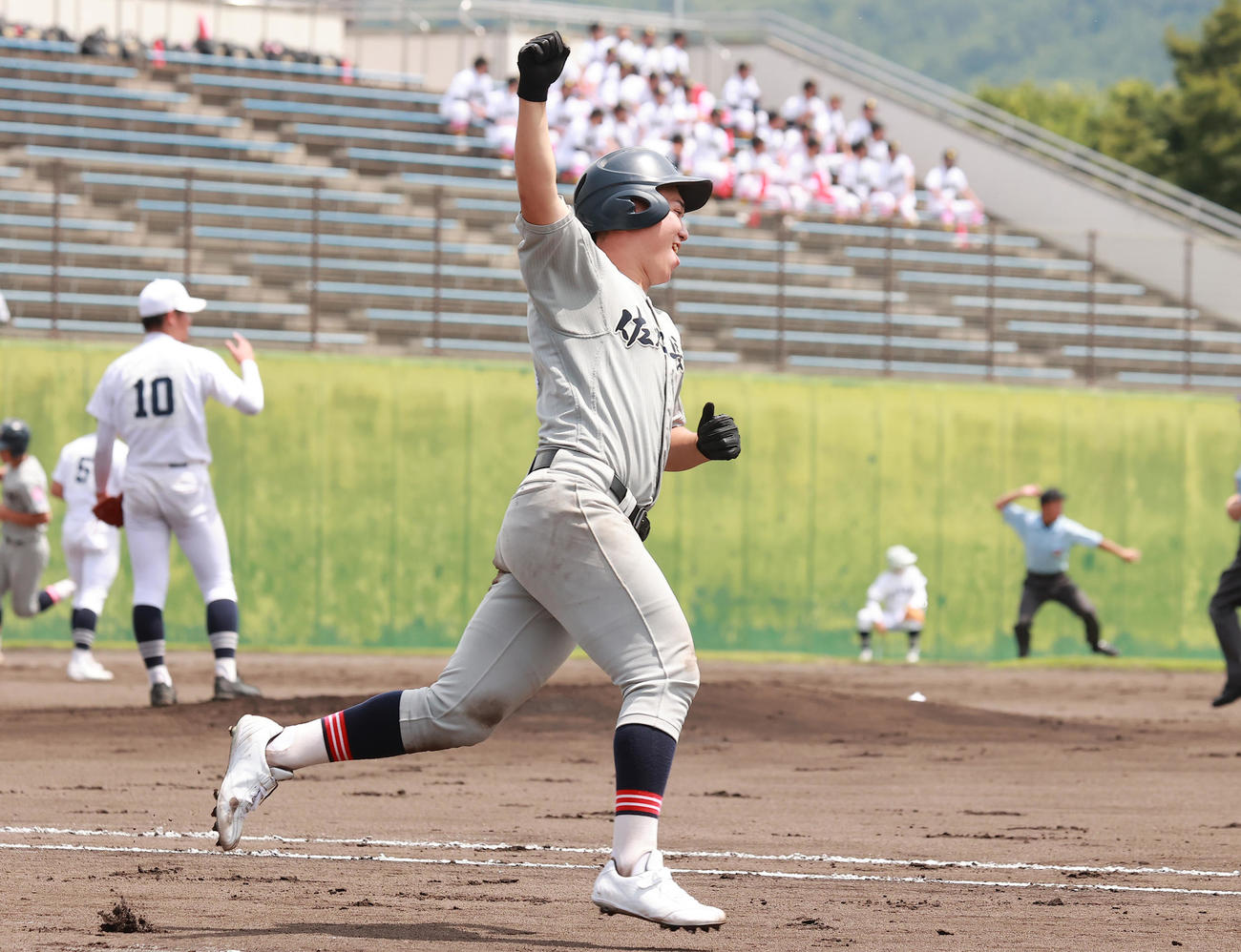飯山対佐久長聖　6回裏佐久長聖1死二塁、左越え2点本塁打でコールド勝ちを決め、ガッツポーズで一塁に向かう良元（撮影・野上伸悟）