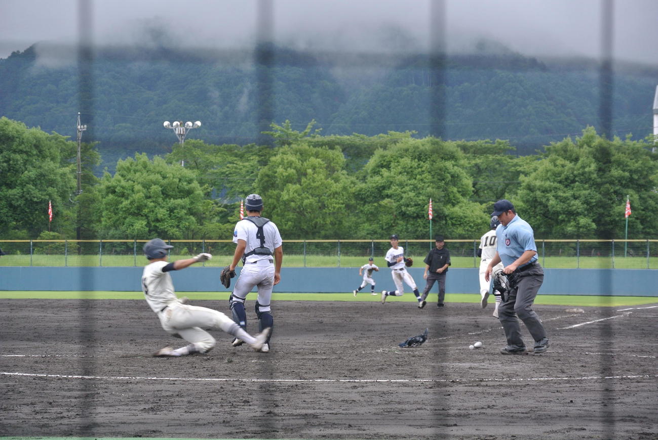5回裏、スクイズで滑り込む飯田の主将宮下智貴の生還を確認する花井弘樹球審と、飯田OIDE長姫の主将熊谷雄大捕手（撮影・井上真）