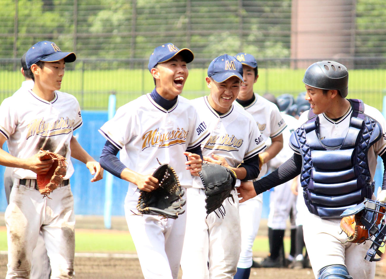 3回表、投ゴロをお腹で止め、苦笑いで痛がる宮代の石鍋投手（右から2人目）と笑顔で駆け寄るチームメート（撮影・保坂恭子）
