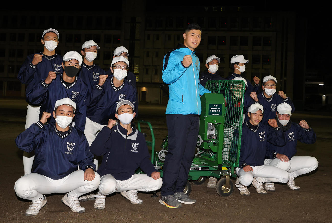 母校仁川学院高野球部にバッティングマシンを贈呈した佐藤（中央）は、ナインと写真に納まる（2021年1月4日撮影）