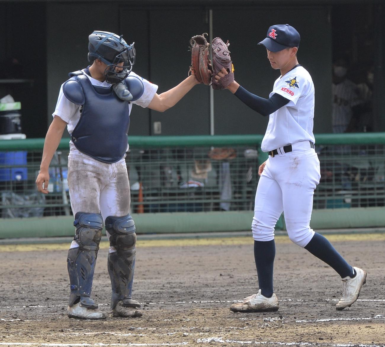 試合に勝利しグラブタッチする福島工の小坂英（右）と小坂健