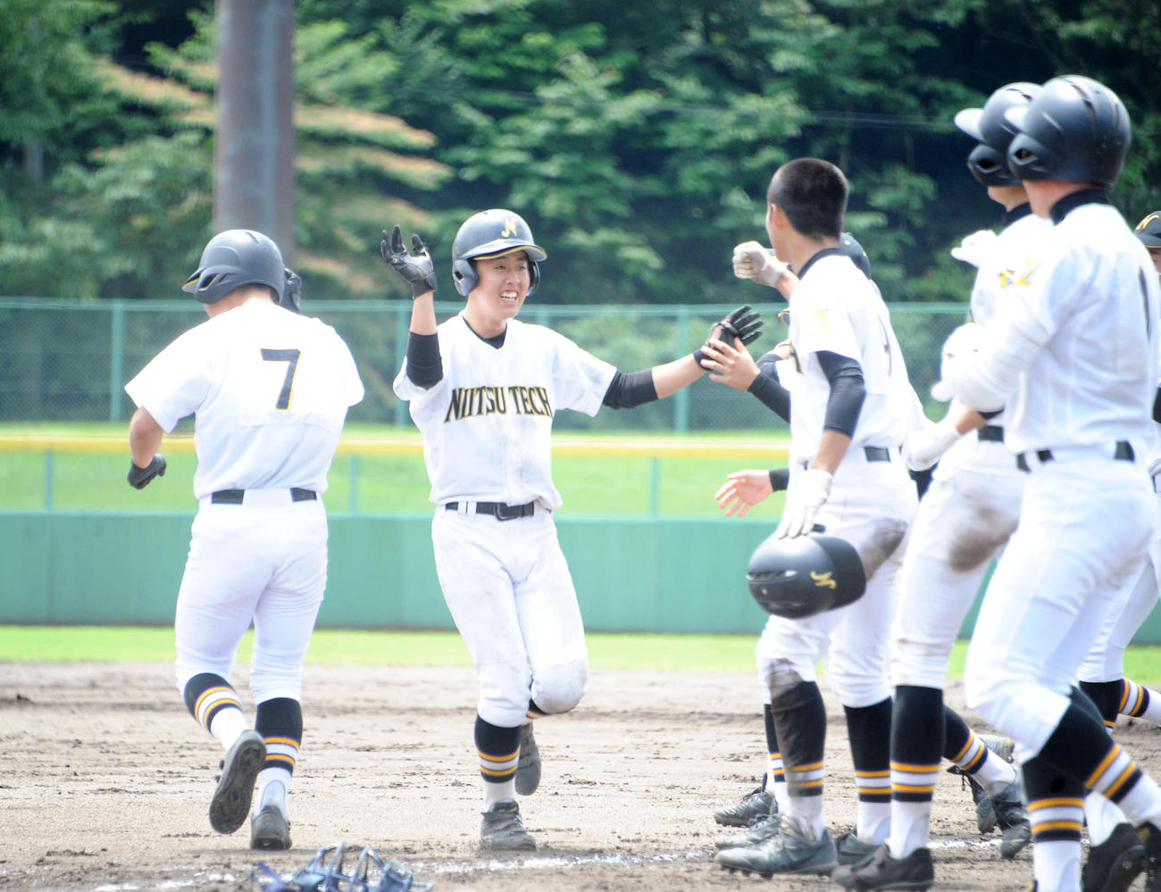逆転サヨナラ打を放った新津工・田井（左から2人目）はチームメートに迎え入れられ笑顔を見せる（撮影・斎藤慎一郎）