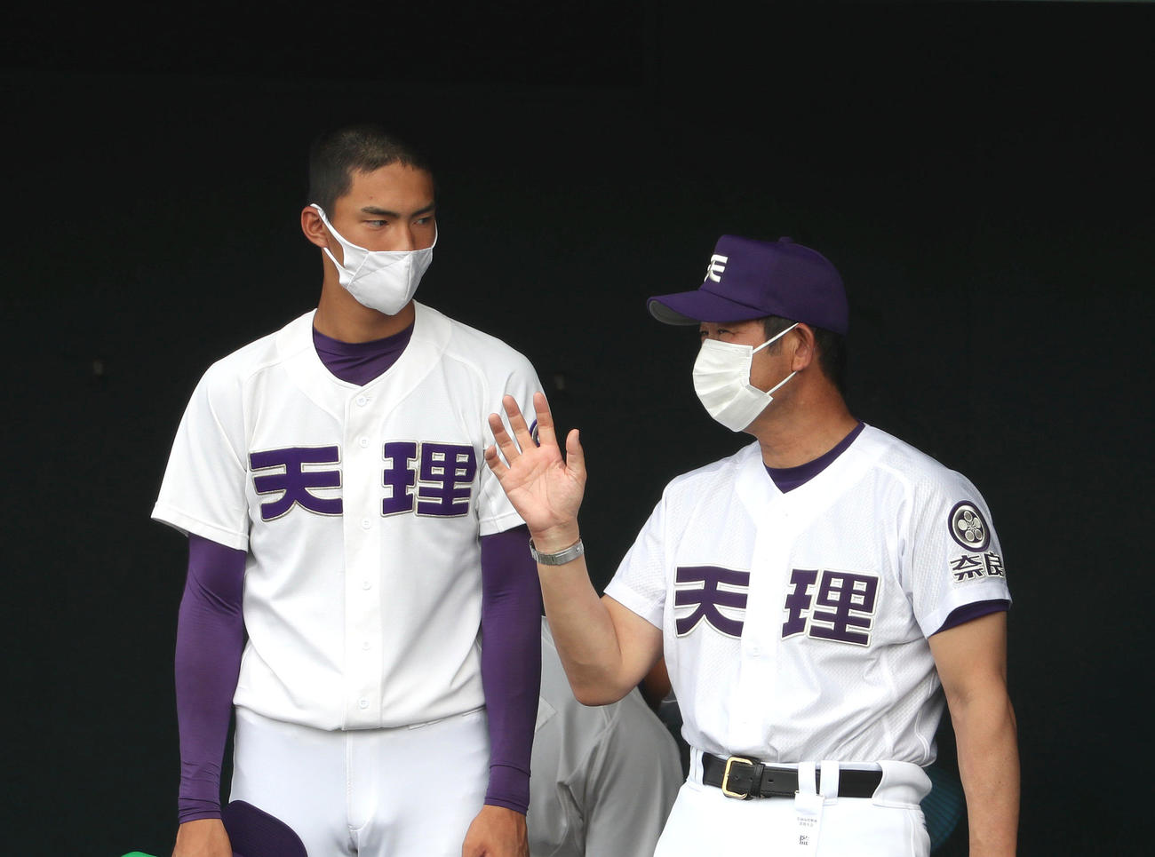 試合中、ベンチで中村良二監督の話を聞く天理・達孝太（左）（撮影・白石智彦）