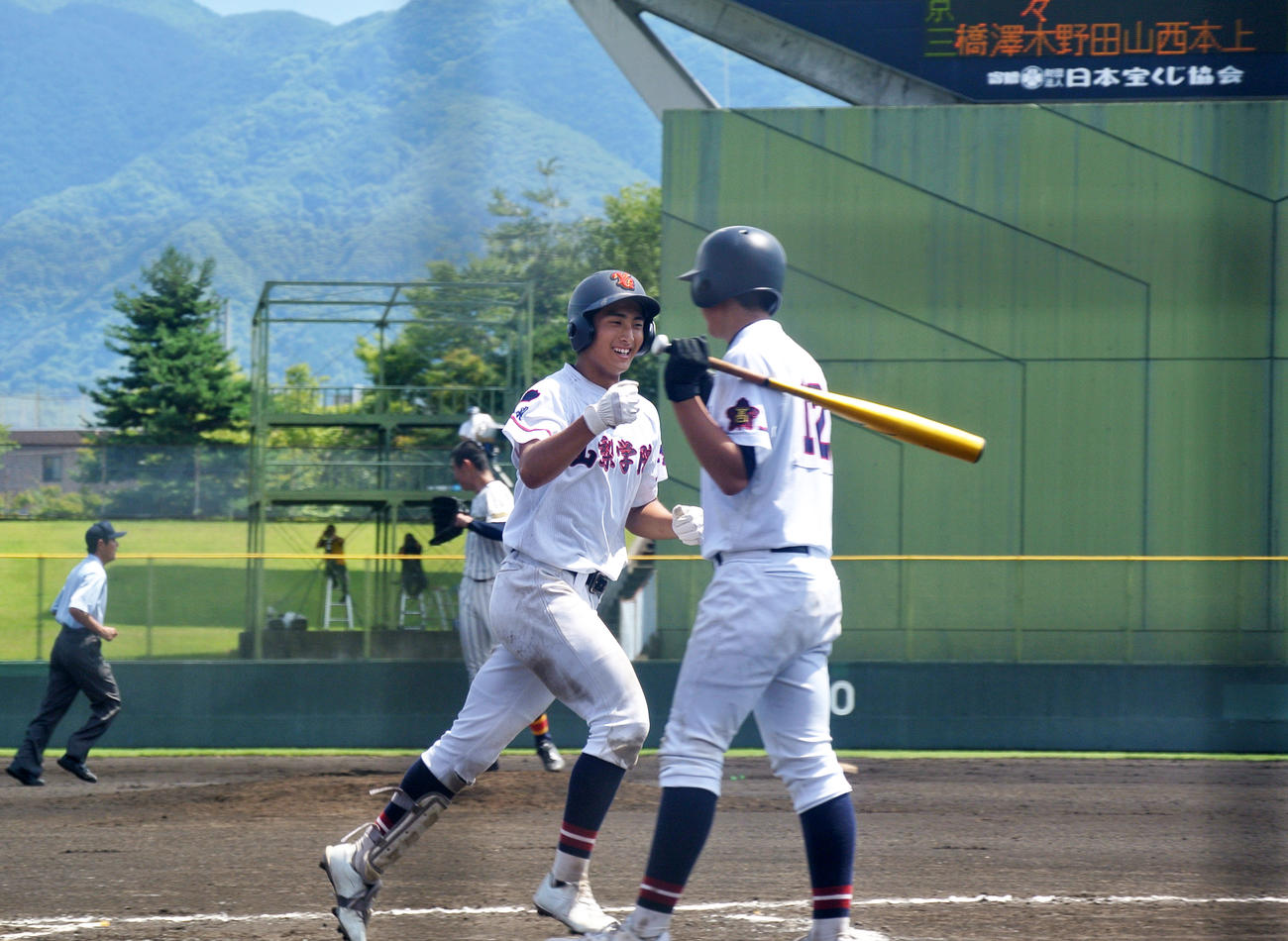 山梨学院・甚野は左中間に2ランを放ち、次打者の佐仲とグータッチ（撮影・井上真）