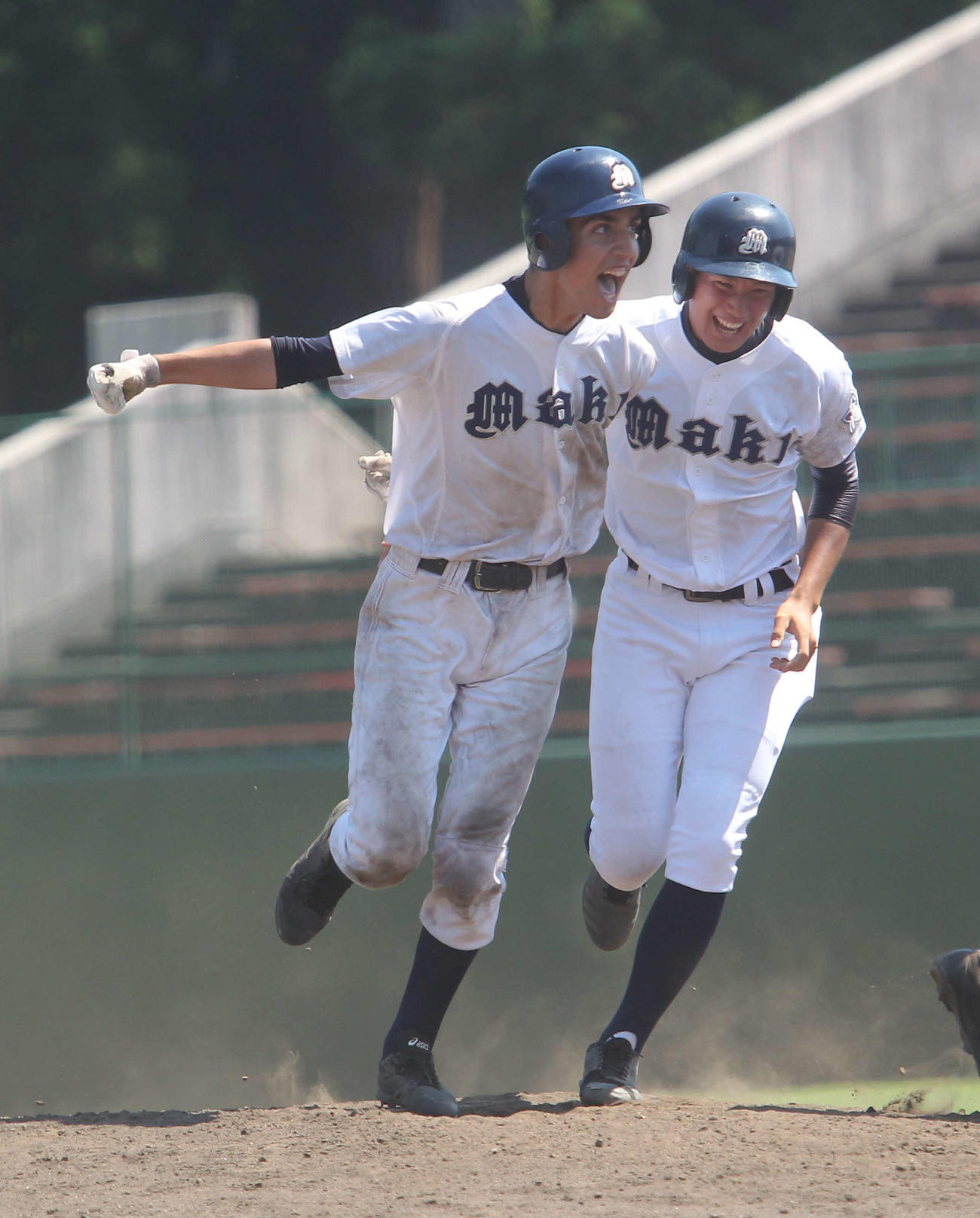 巻対新井　2－2の延長11回1死満塁にサヨナラスクイズを決めた巻のバロリ（左）は一塁コーチ小林と肩を組みながら雄たけび