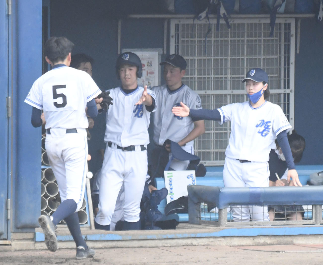箕面自由学園対追手門学院　選手とハイタッチをかわす箕面自由学園・山田幸恵監督（右）（撮影・滝沢美穂子）