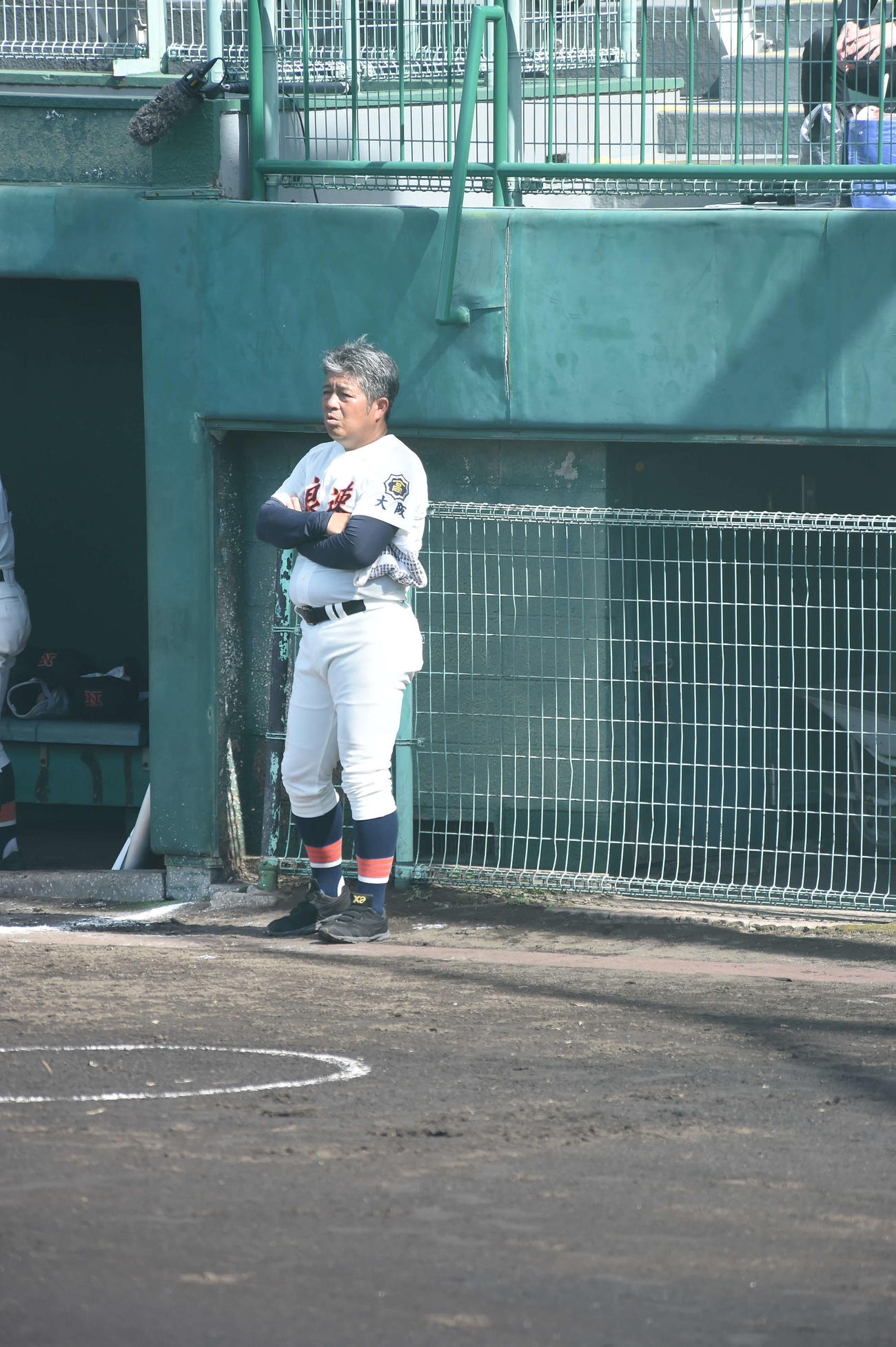 試合前、相手校の練習を見つめる浪速・遠山昭治監督