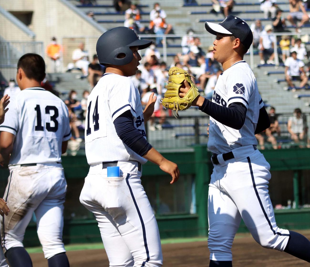 札幌第一対札幌大谷　4回を三者凡退に抑え、ベンチ前でチームメートとグラブタッチする札幌第一の帯川（右）（撮影・永野高輔）