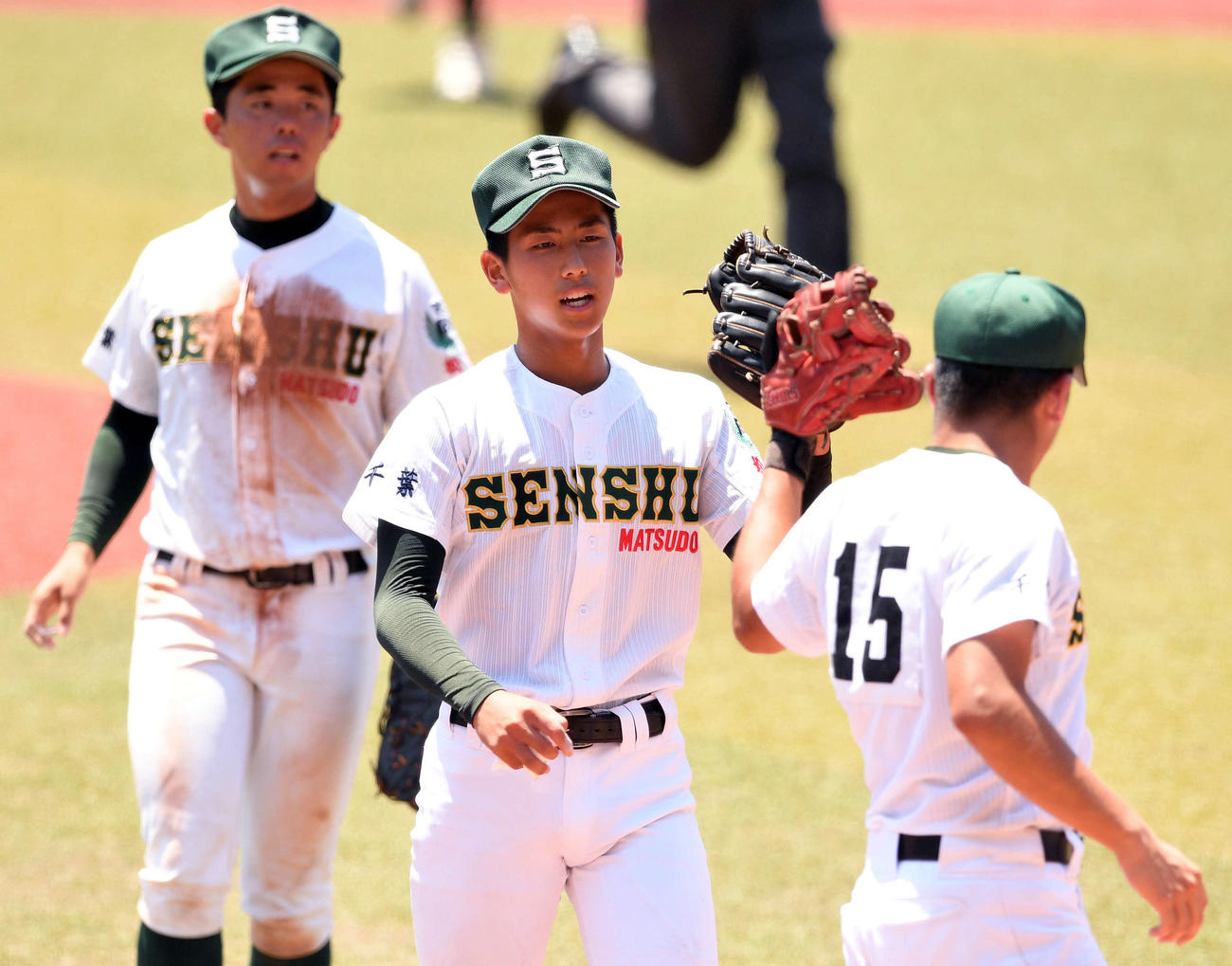 八千代松陰対専大松戸　完投勝利の専大松戸・深沢（中央）はナインとタッチを交わす（撮影・滝沢徹郎）