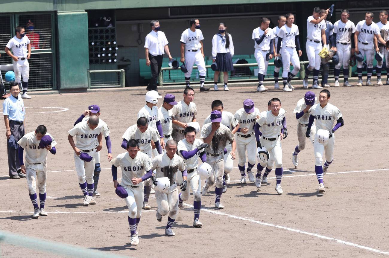 高校野球鳥取県大会　米子松蔭対境　駆け出す米子松蔭ナイン。奥は破れた境ナイン（撮影・加藤孝規）