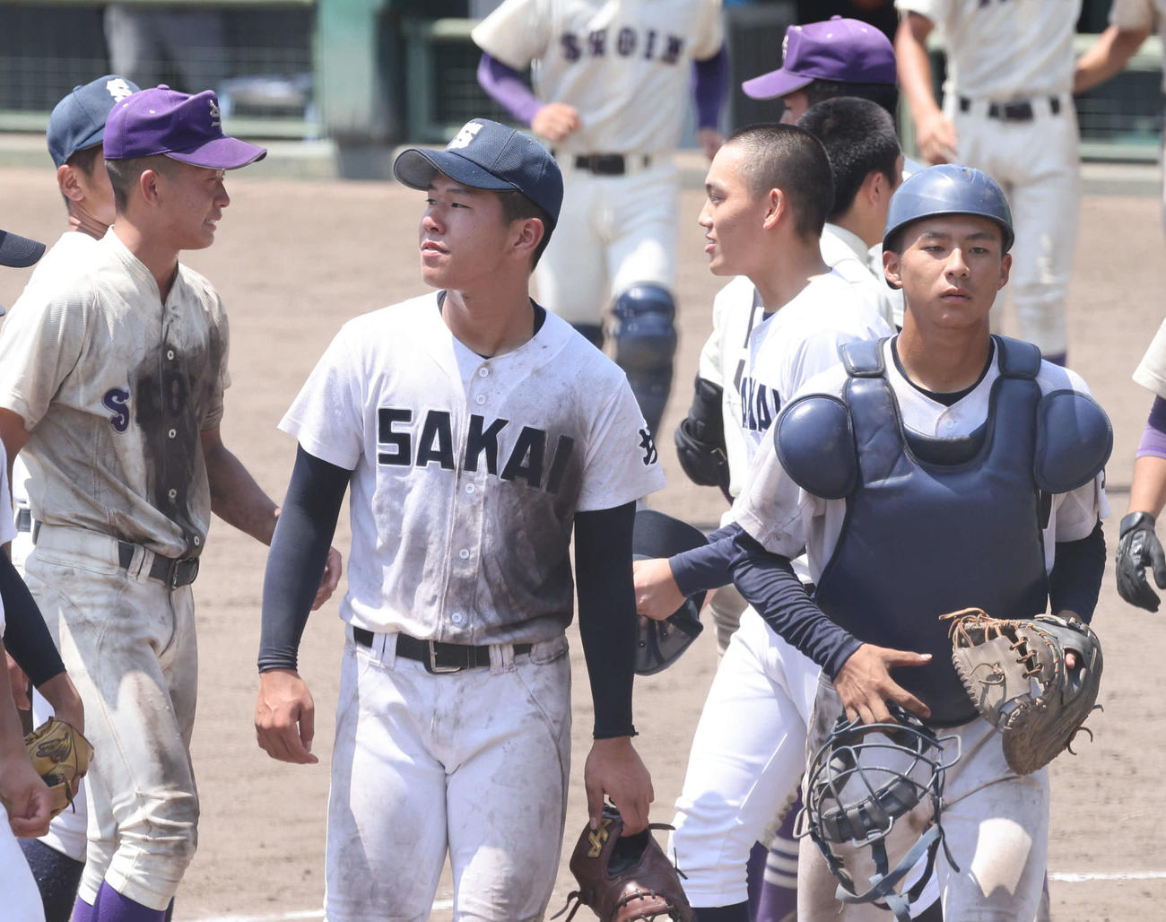 米子松蔭対境　試合終了直後、米子松蔭ナインと健闘ををたたえ合う境・井上翔太主将（左から4人目）（撮影・加藤孝規）