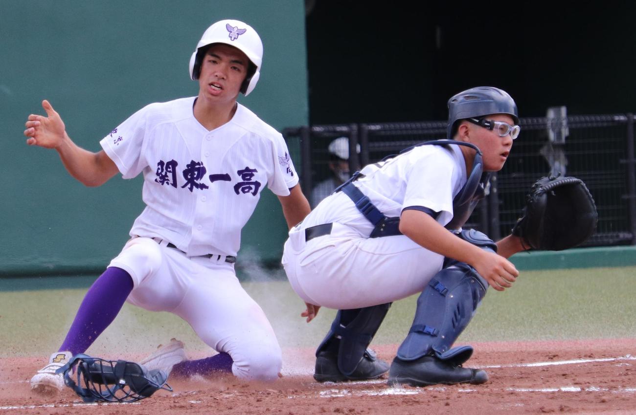 足立西対関東第一　1回裏関東第一1死一塁、初谷の右翼線二塁打で一塁から一気に生還する五十嵐（左）。右は足立西の捕手・高平（撮影・古川真弥）