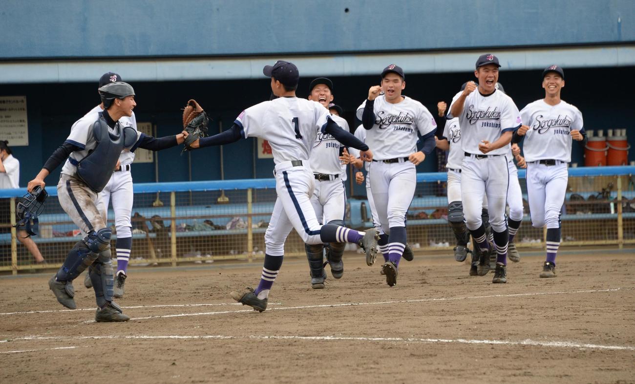 慶応対横浜創学館　勝利を決めた横浜創学館・山岸（中央）は井上捕手とグラブタッチ（撮影・鈴木正章）