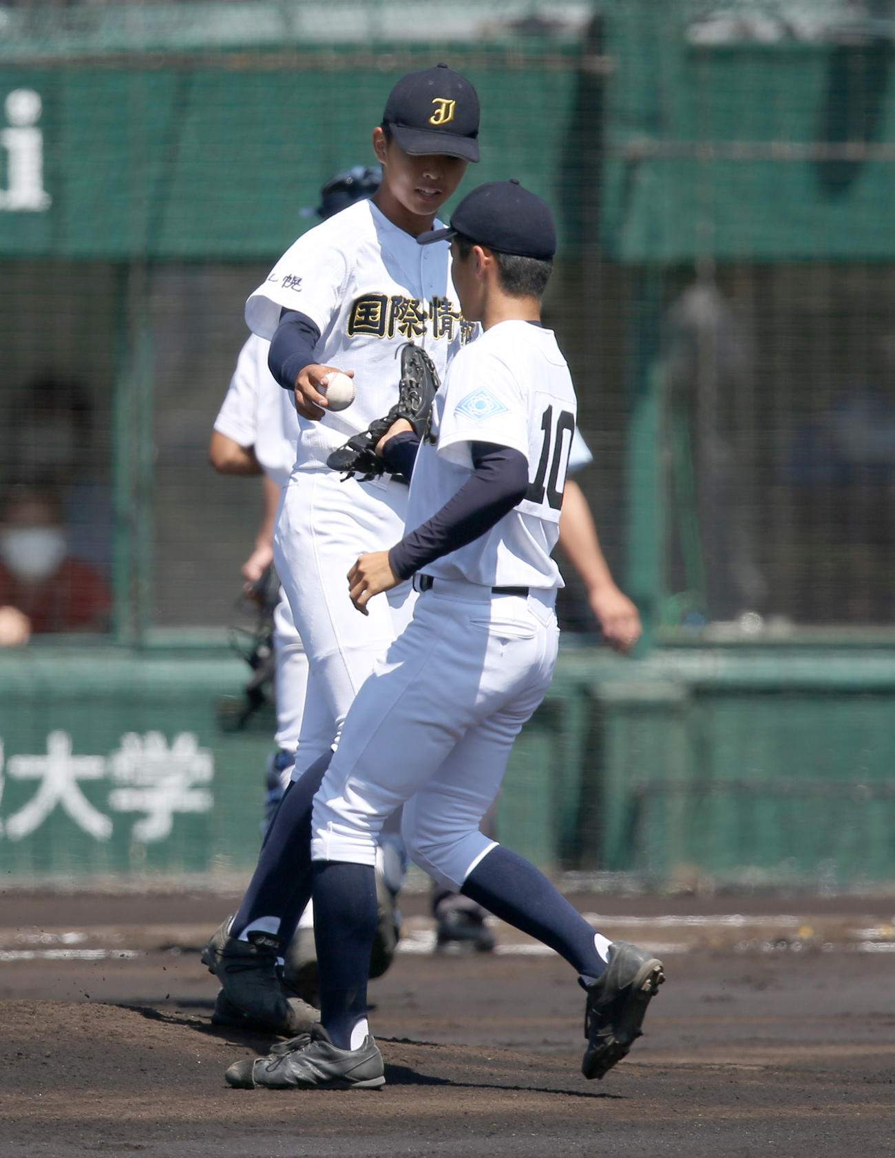 札幌日大対札幌国際情報　1回途中で降板する札幌国際情報・平川（中央奥）は木村にボールを手渡す（撮影・佐藤翔太）