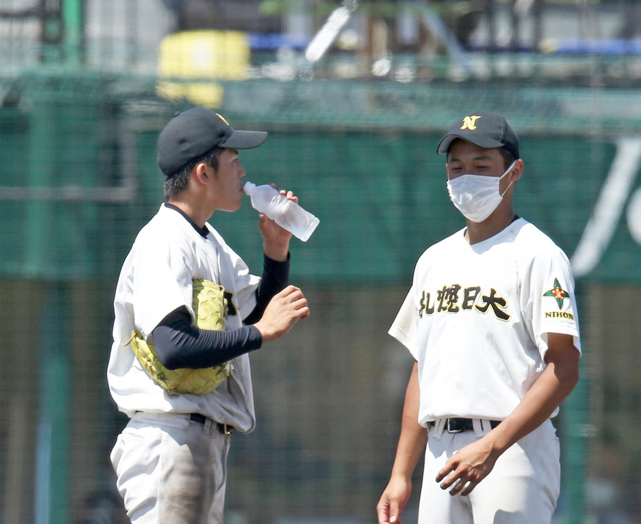 8回裏途中、札幌日大・前川佳央（左）は弟の周也が届けた水を飲む（撮影・佐藤翔太）