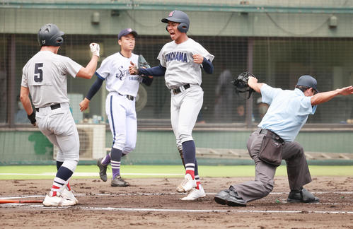 横浜創学館対横浜　1回裏横浜2死一塁、立花祥希の右前打と敵失で先制の生還をし喜ぶ金井。奥は横浜創学館・山岸（撮影・野上伸悟）