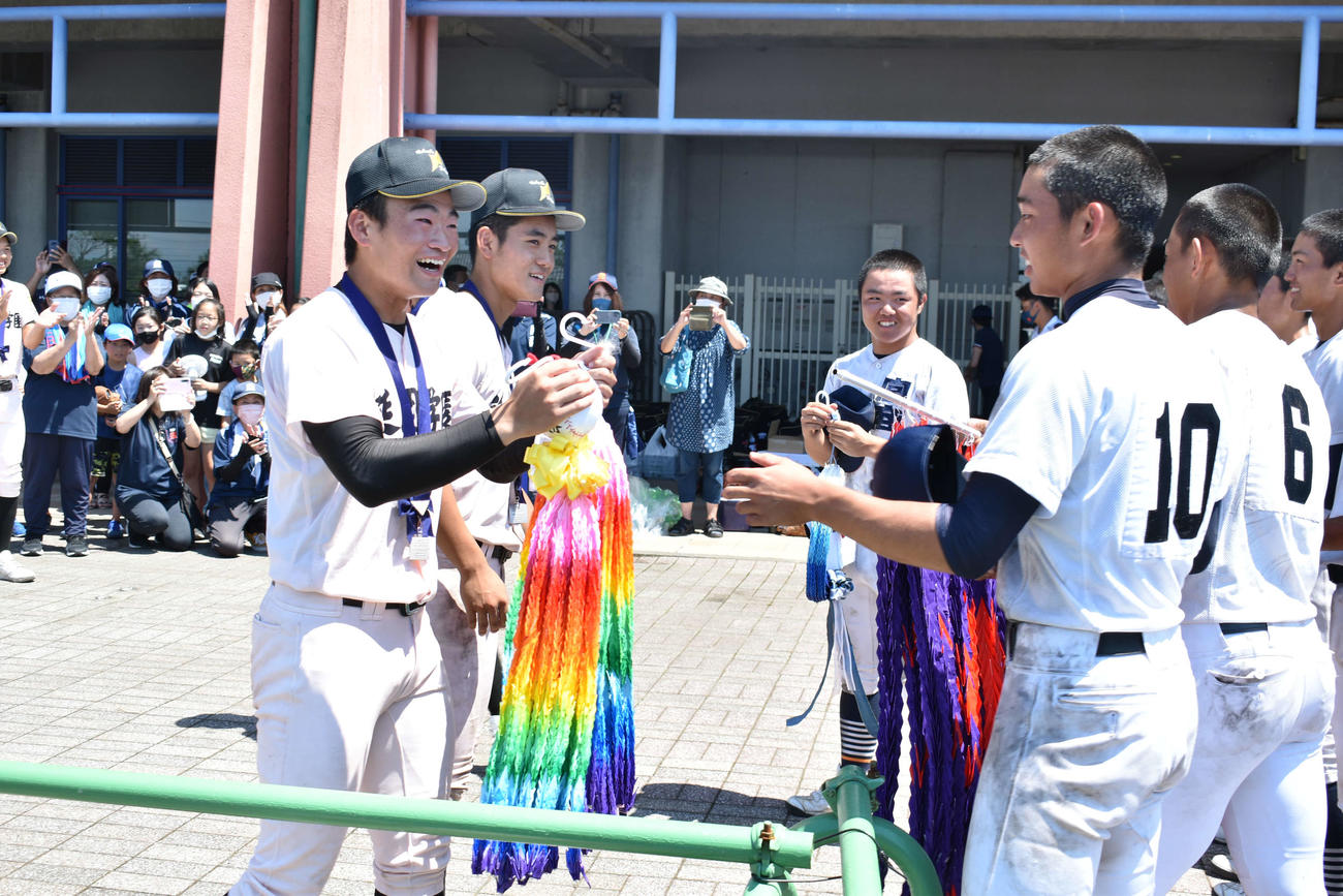 千羽鶴を宮崎商に渡し、激励する準優勝の延岡学園の選手（左）（撮影・只松憲）